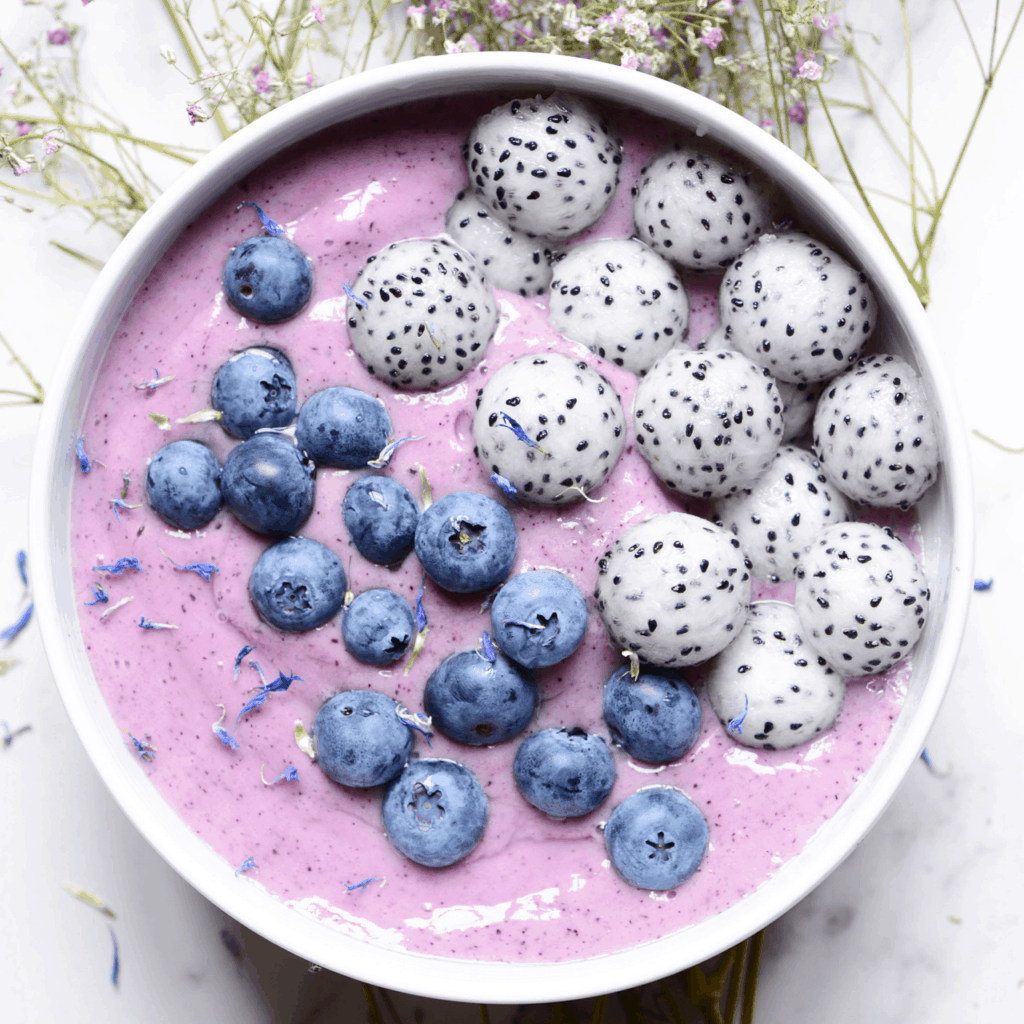 Blueberry and kale smoothie bowl topped with blueberries and dragon fruit balls