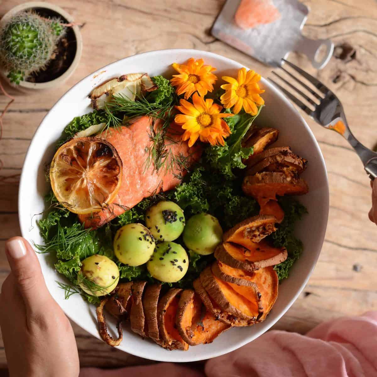 Grilled salmon with cake and baked sweet potato in a bowl