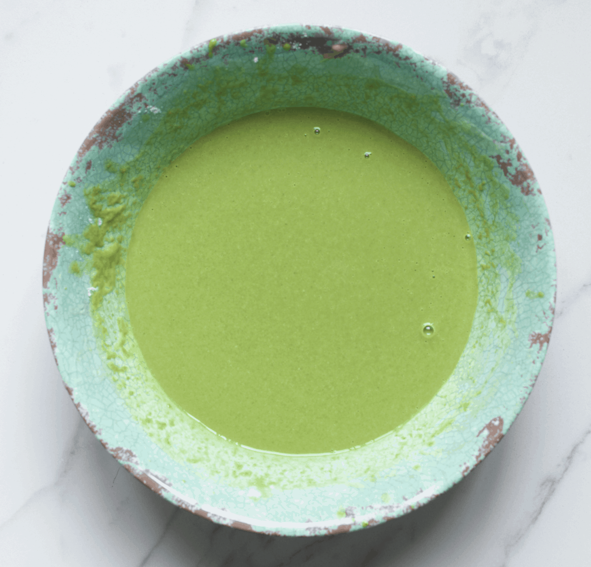 Green waffle batter in a green bowl 