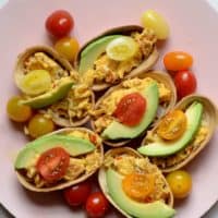 Breakfast tacos topped with avocado and cherry tomatoes