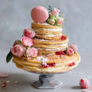 Pancake cake with roses, jam, coconut cream frosting, macaron