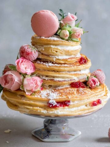 Pancake cake with roses, jam, coconut cream frosting, macaron