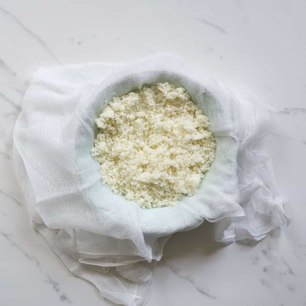Blended cauliflower over a muslin cloth over a bowl