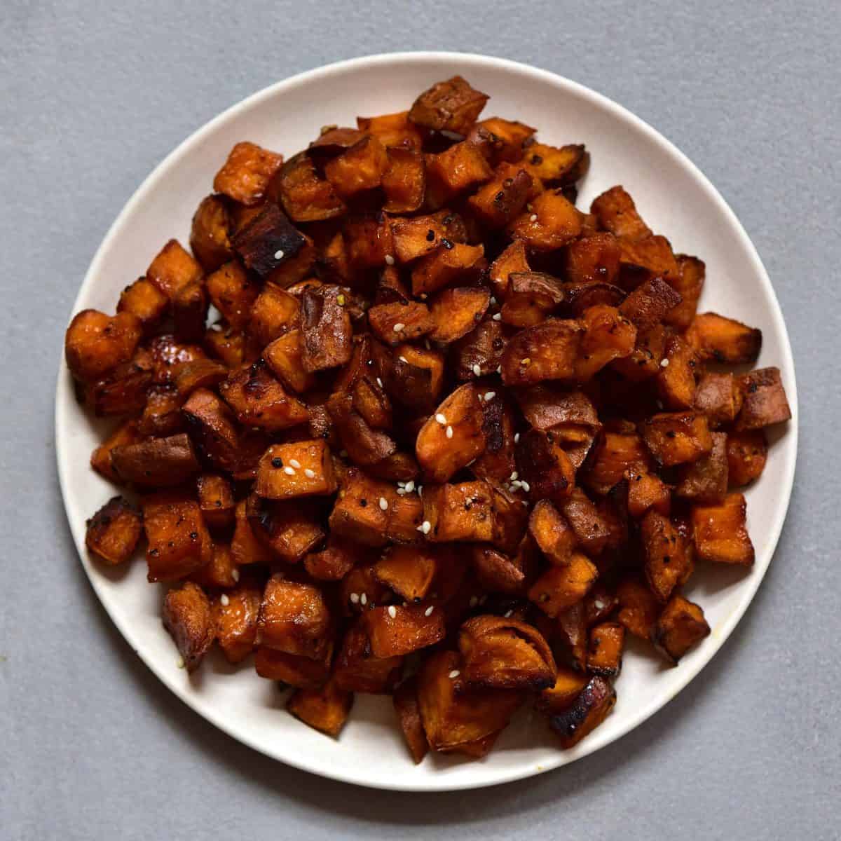 Baked sweet potato cubes on a white plate