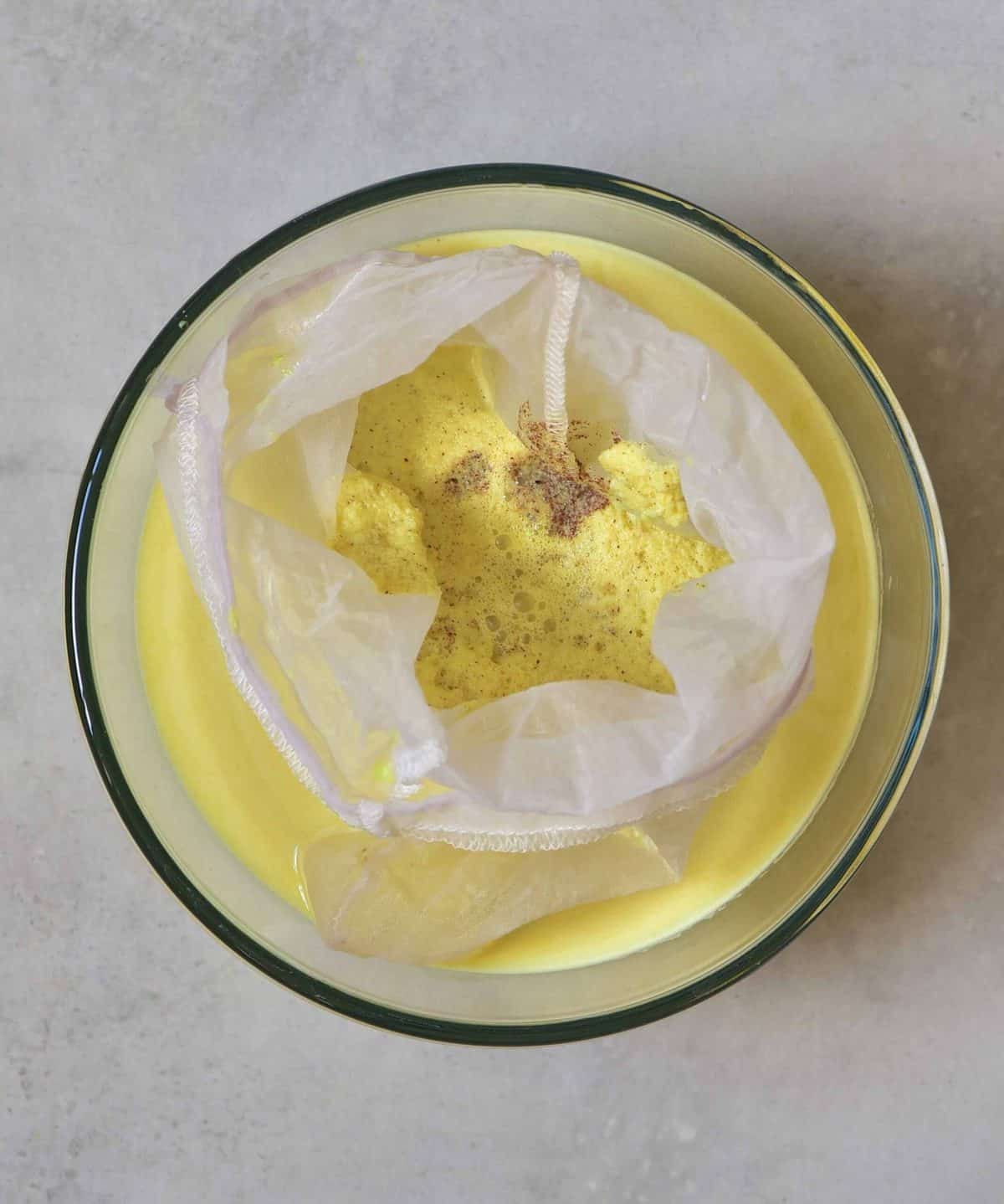 Golden milk - freshly made, poured into a nut milk bag