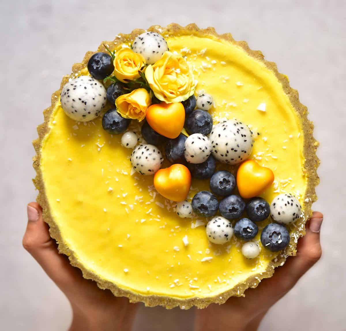 vegan pistachio & lemon tart topped with dragon fruit, roses and blueberries