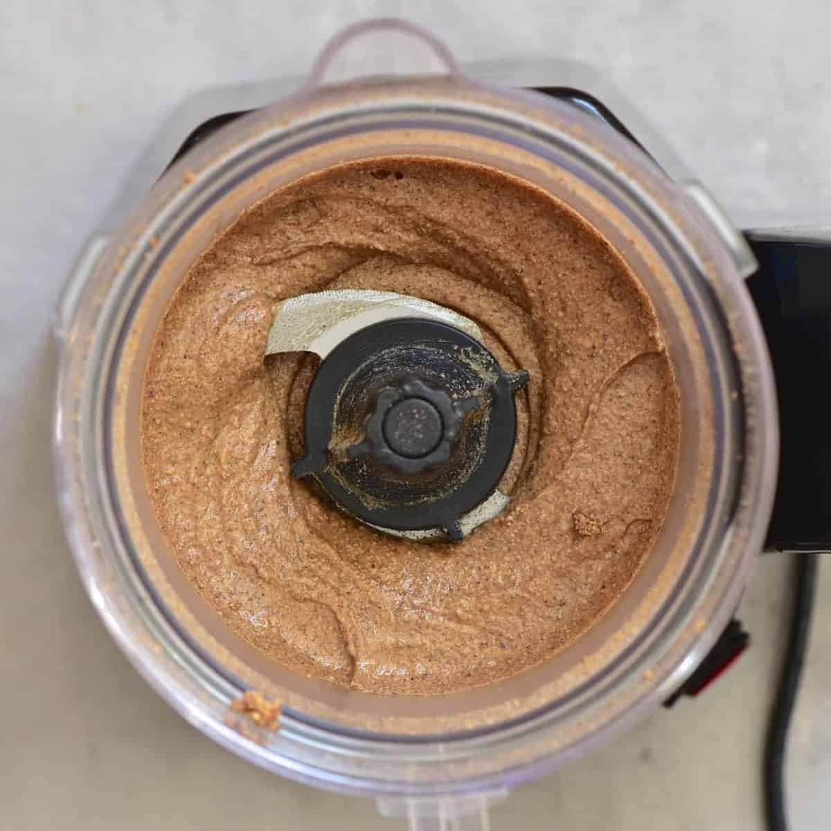 thick almond paste inside a food processor