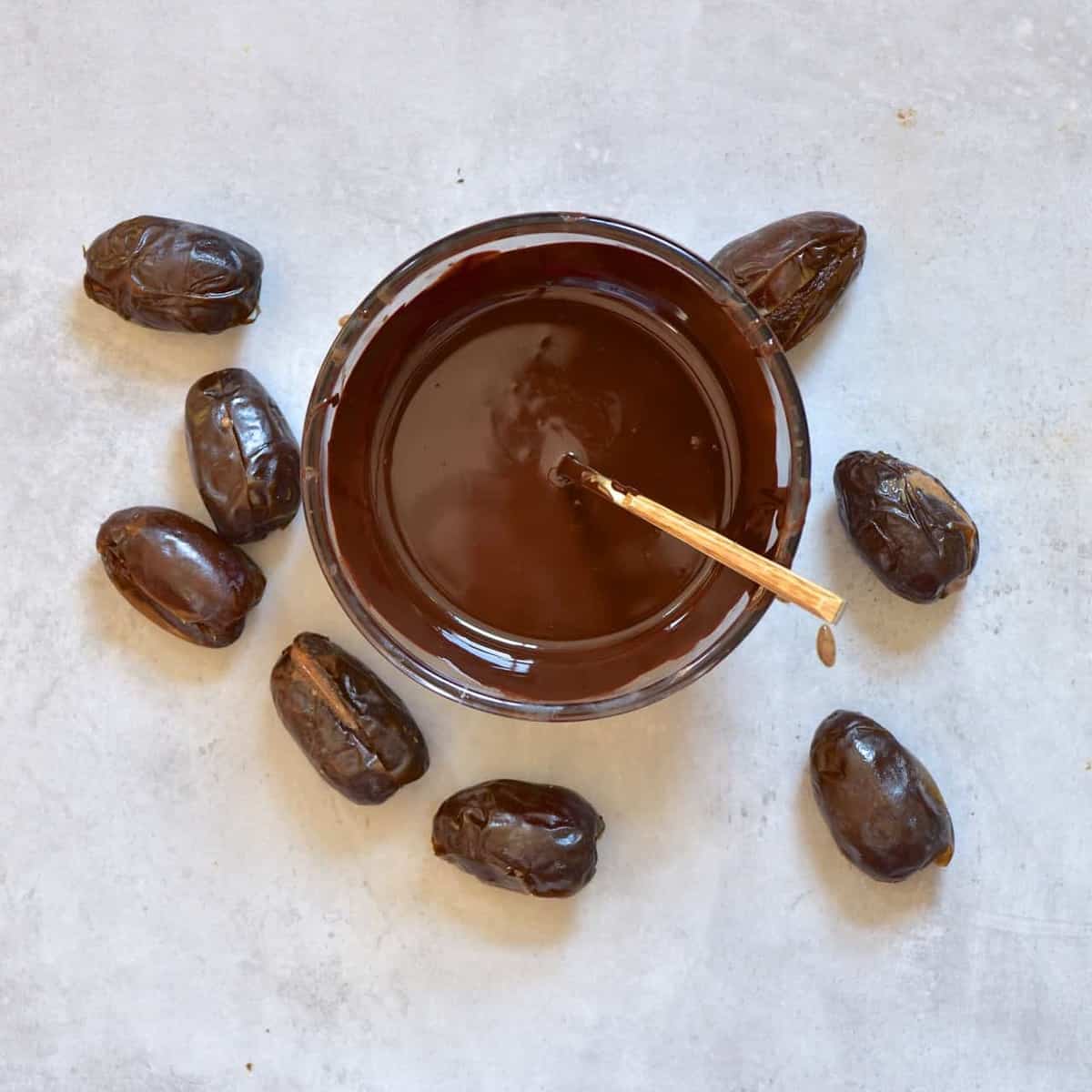 jar of melted dark chocolate and the stuffed dates