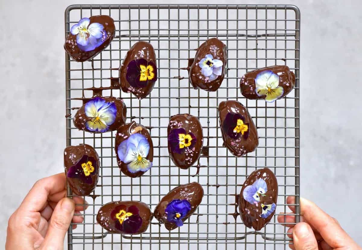 Chocolate coated dates decorated with edible flowers