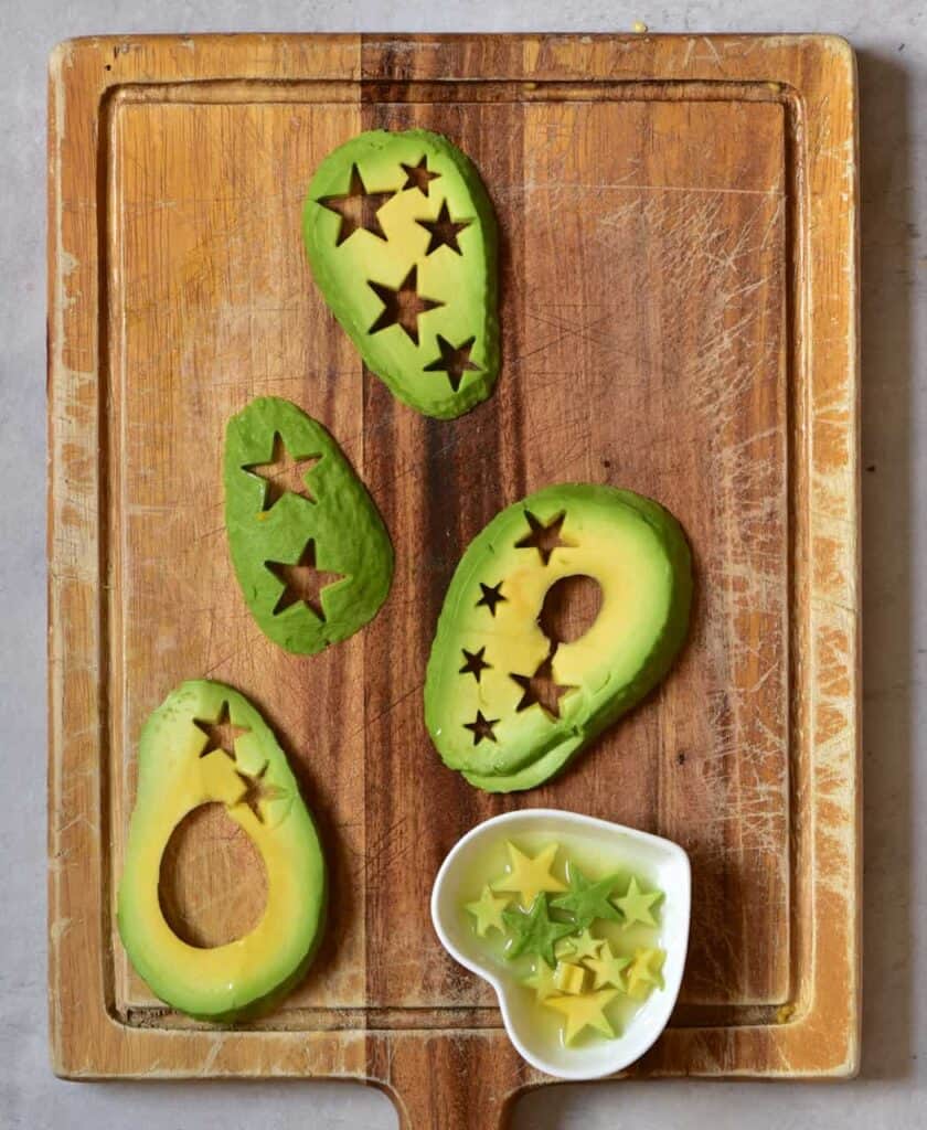 Cutting out starts from avocado slices on a wooden board