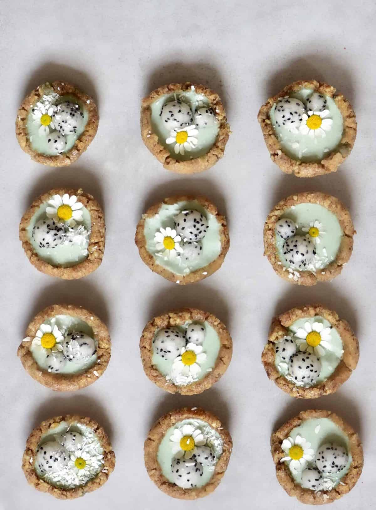 Mini green tarts with dragonfruit balls, coconut, and daisy flowers