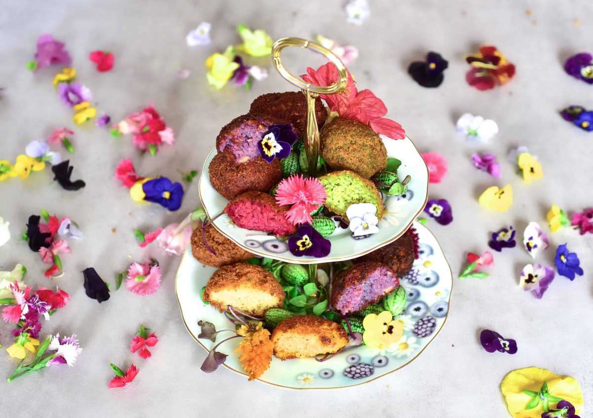 Rainbow falafel with veggies and edible flowers as part of a mezze platter