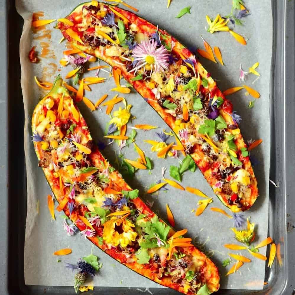 Zucchini boats stuffed with veggies and decorated with edible flowers