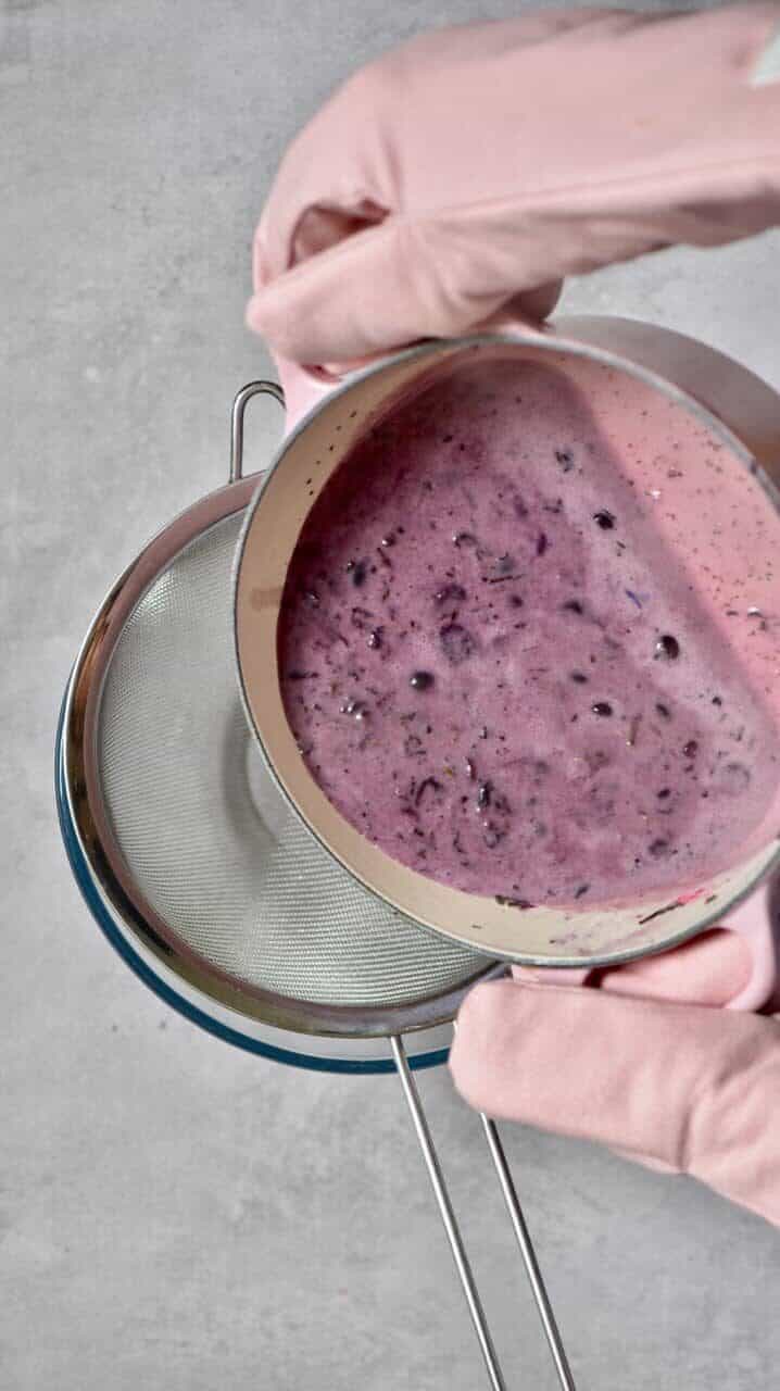 Sieving coconut milk and blueberry tart filling