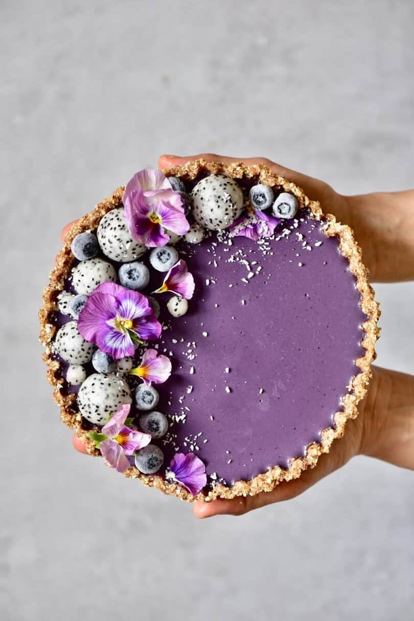 no bake blueberry tart held up by hands