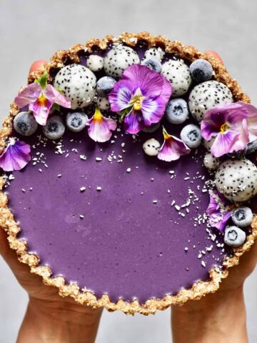 healthy refined sugar free, raw vegan earl grey blueberry tart with dragon fruit and edible flowers