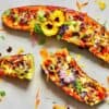 Zucchini boats stuffed with colorful veggies and topped with edible flowers