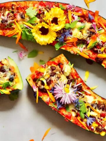 Zucchini boats stuffed with colorful veggies and topped with edible flowers