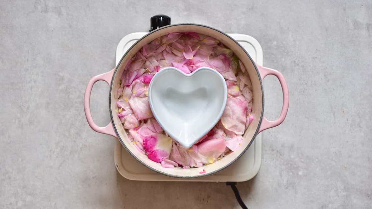 a pot with rose petals and a bowl