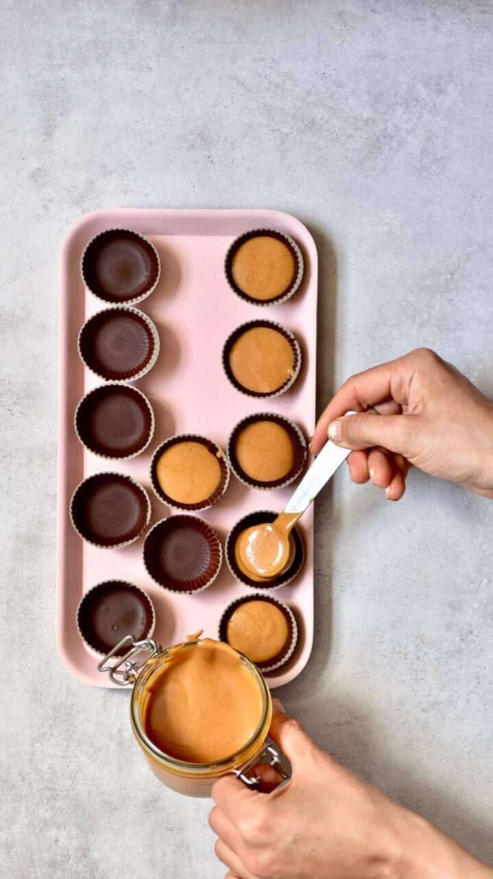 Adding peanut butter to chocolate coated mold for making peanut butter and chocolate cups