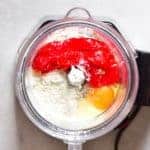 A blender with flour red pepper and an egg