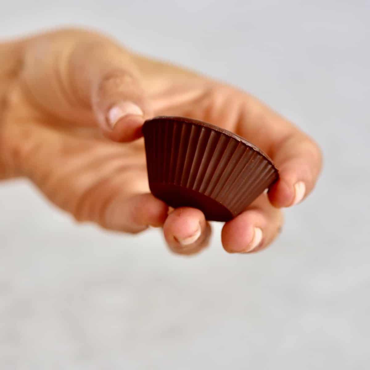 holding 1 chocolate peanut butter cup 