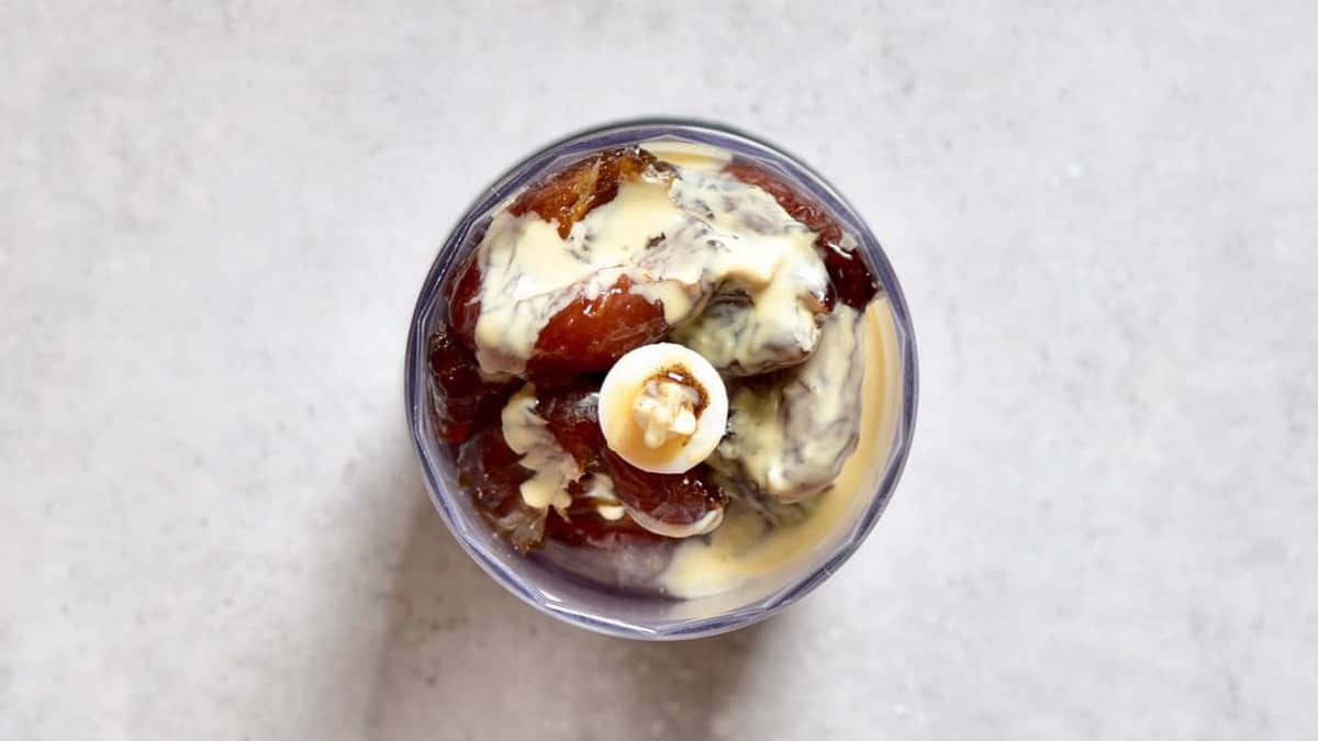 A small blender bowl filled with dates and tahini
