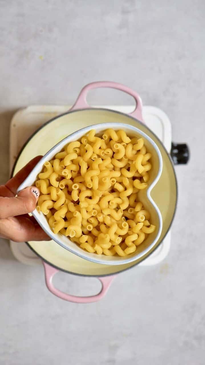 Dried macaroni pasta over a pot