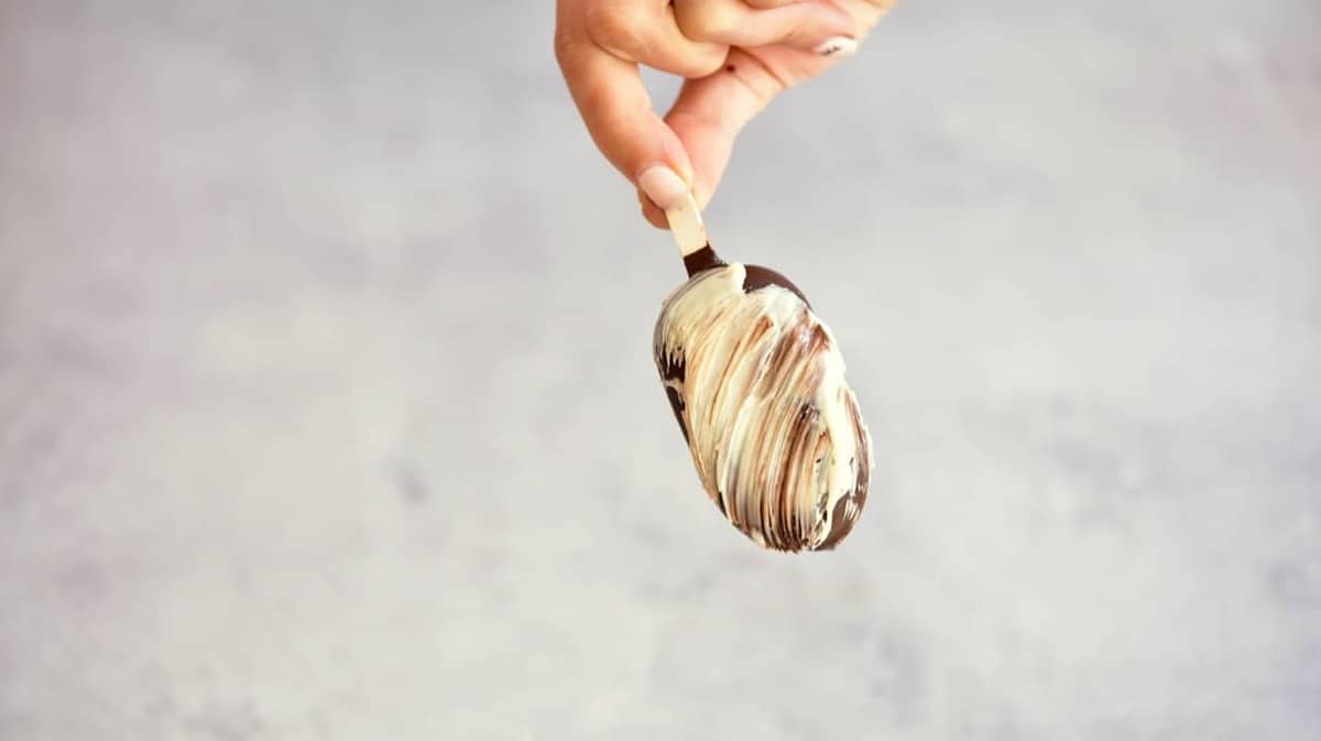 A homemade magnum ice cream with brushed white chocolate coating over dark chocolate 