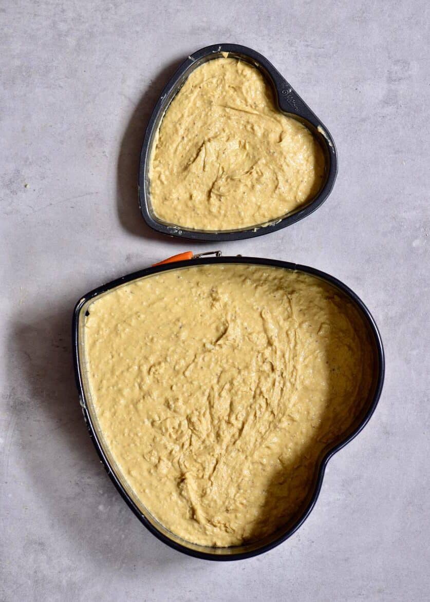 Cake batter in heart-shaped tins ready to bake