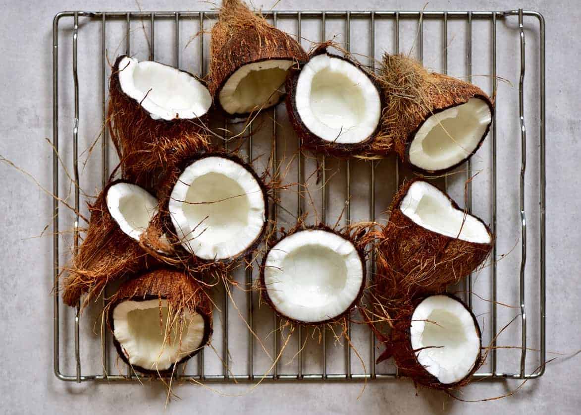 Halved coconuts on a baking rack 