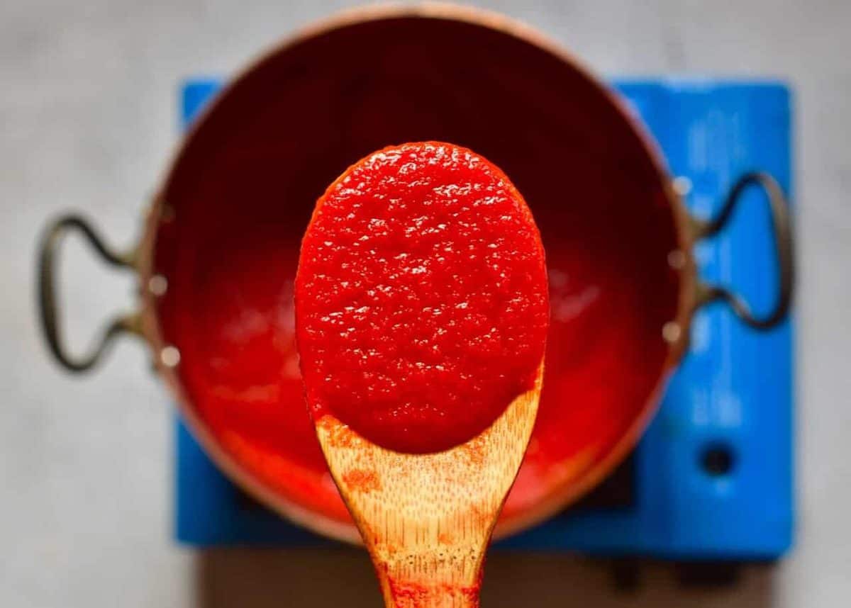 reducing fresh red tomato juice for making homemade tomato puree/ paste