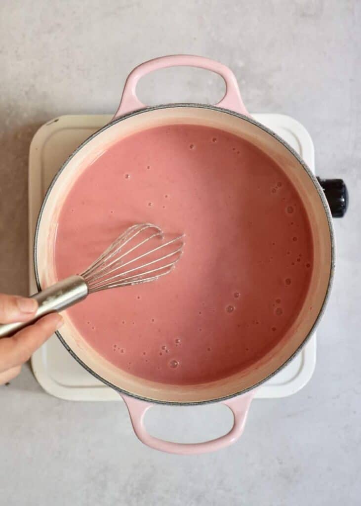 preparing strawberry vegan tart filling in a pan