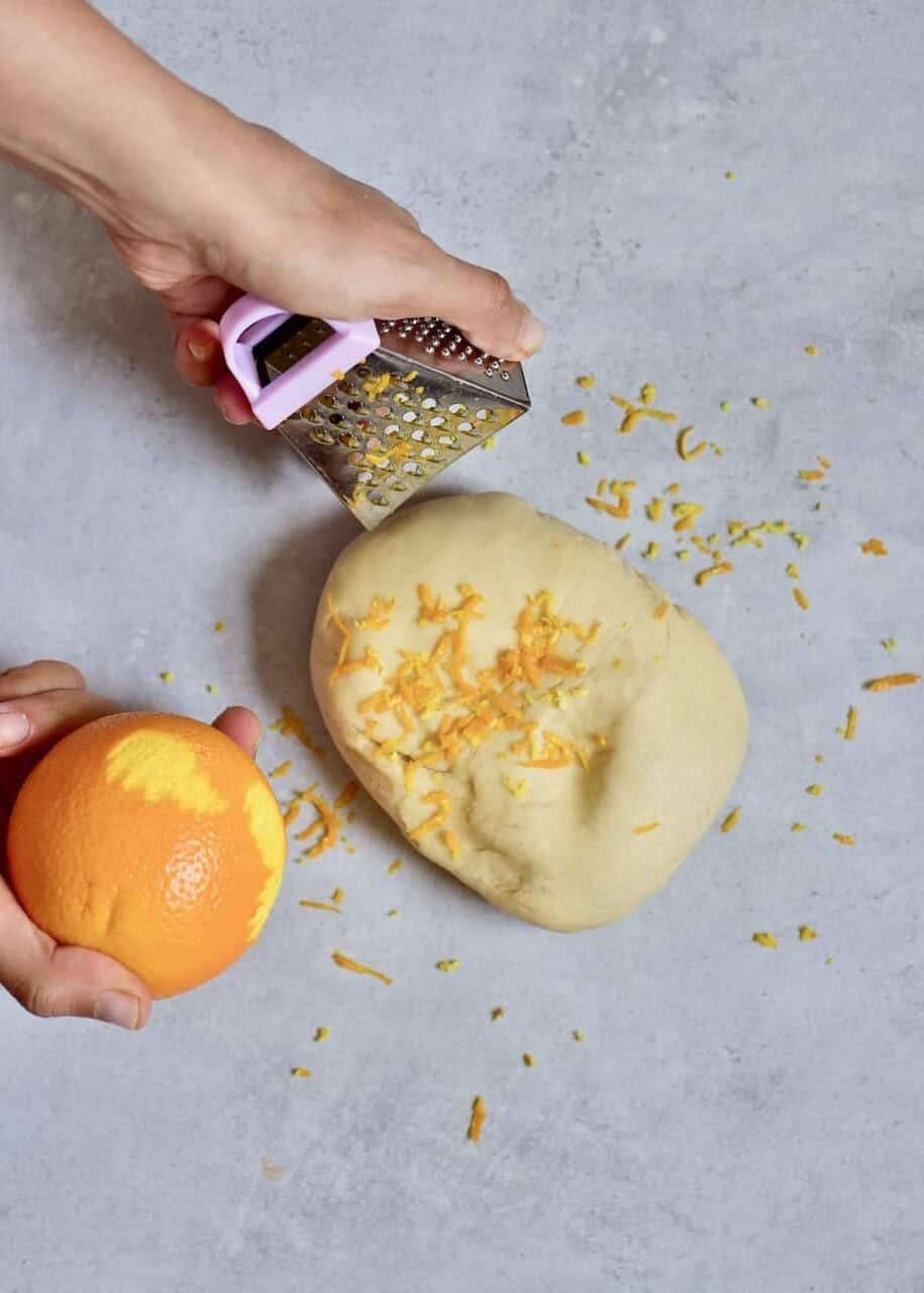 Zesting orange over dough