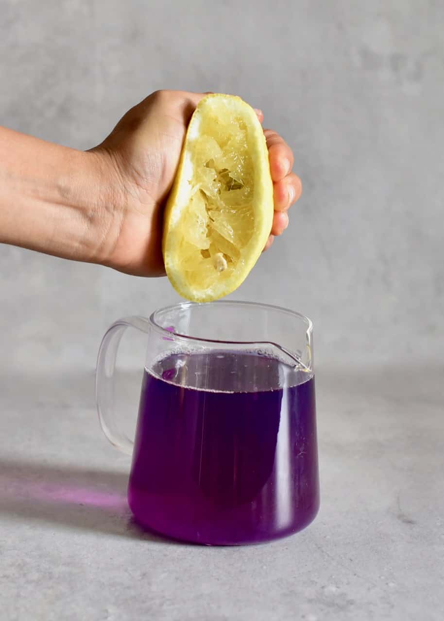 squeezing lemon into butterfly tea jug and the colour turns purple 