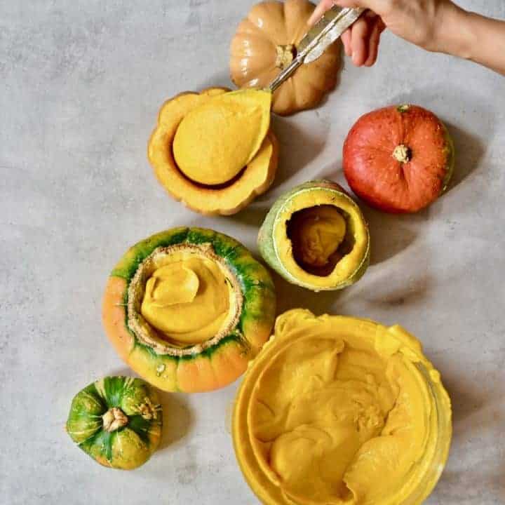 spooning squash and carrot soup into edible pumpkin bowls
