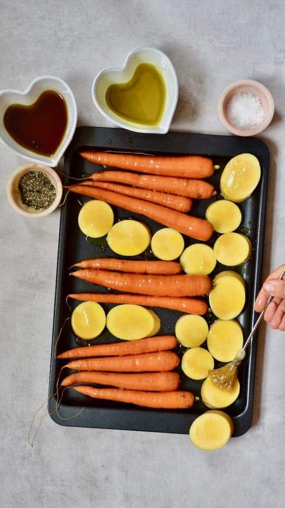 brushing carrots and squash with olive oil