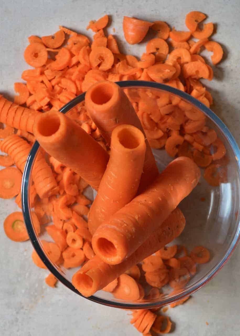 A bowl with cored carrots and carrot leftovers on the side