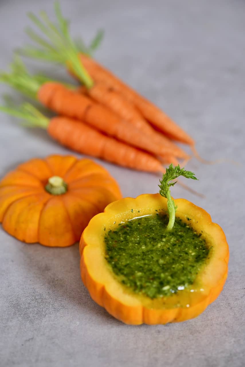 Carrot top pesto in a mini pumpkin and a few carrots next to it