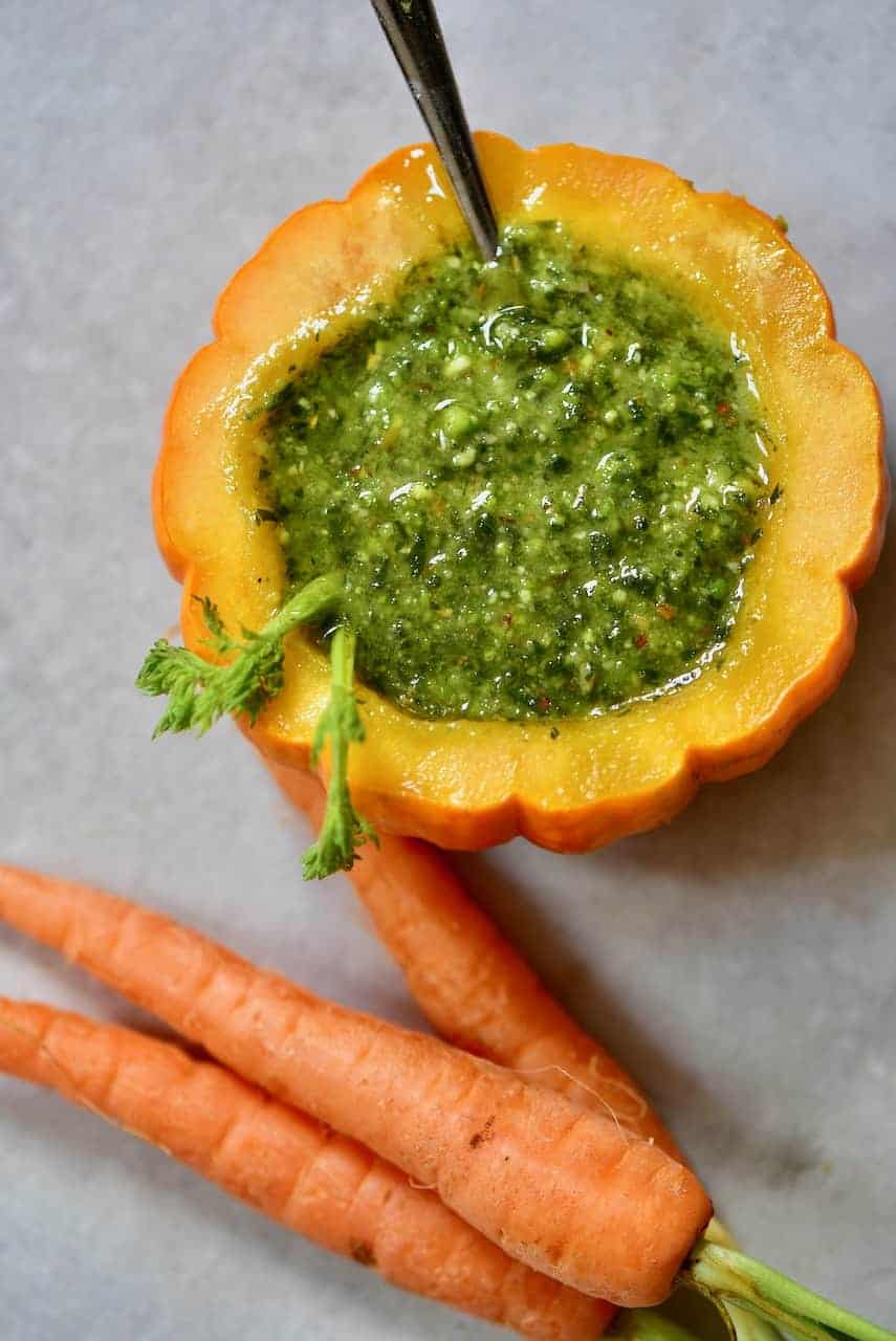 A small pumpkin filled with homemade carrot top pesto