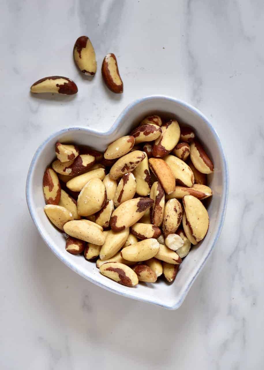 a heart shaped bowl with brazil nuts