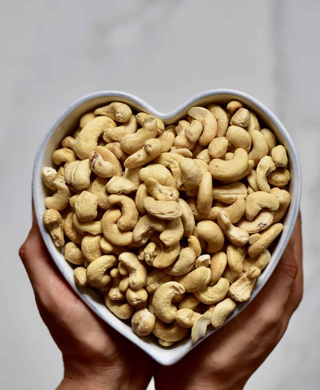cashew nuts in a heart shaped bowl