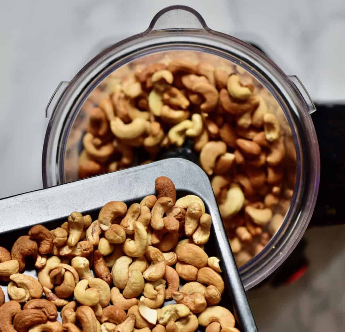 adding toasted cashews to a blender