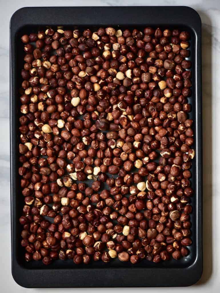 hazelnuts spread on a baking tray to make vegan nutella