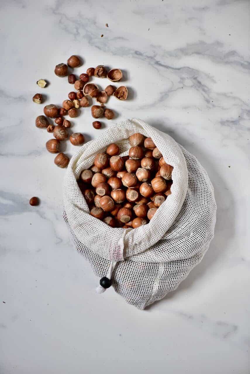 a bag of hazelnuts and some shelled hazelnuts 