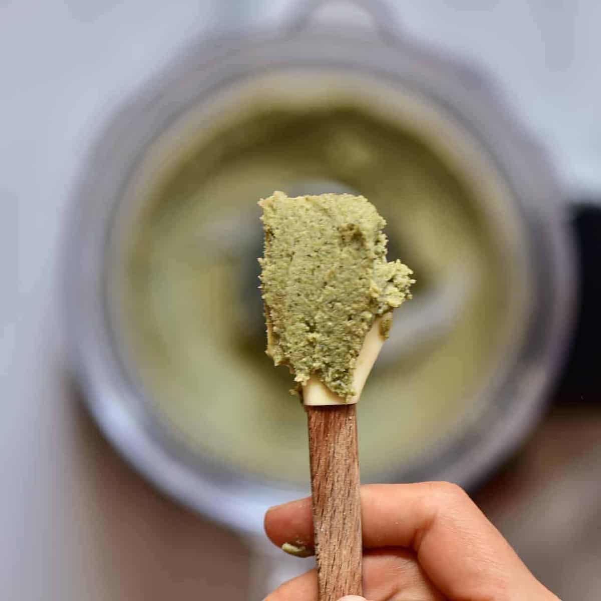 A close up of hemp Butter on a spoon over a blender 