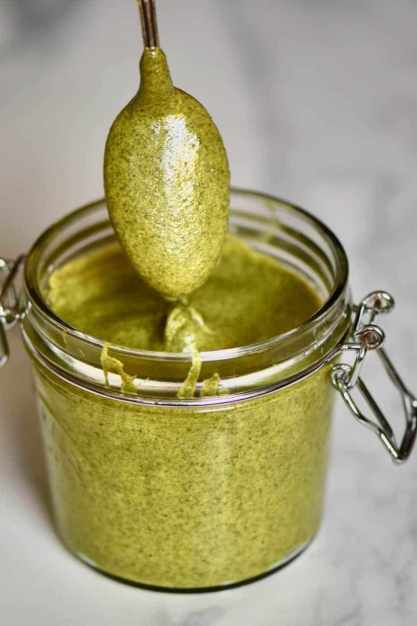 Pumpkin seed butter in a jar and a spoon dipped in it