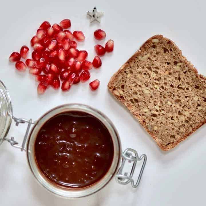 ingredients for homemade healthy christmas toast with healthy vegan nutella spread and pomegranate seeds