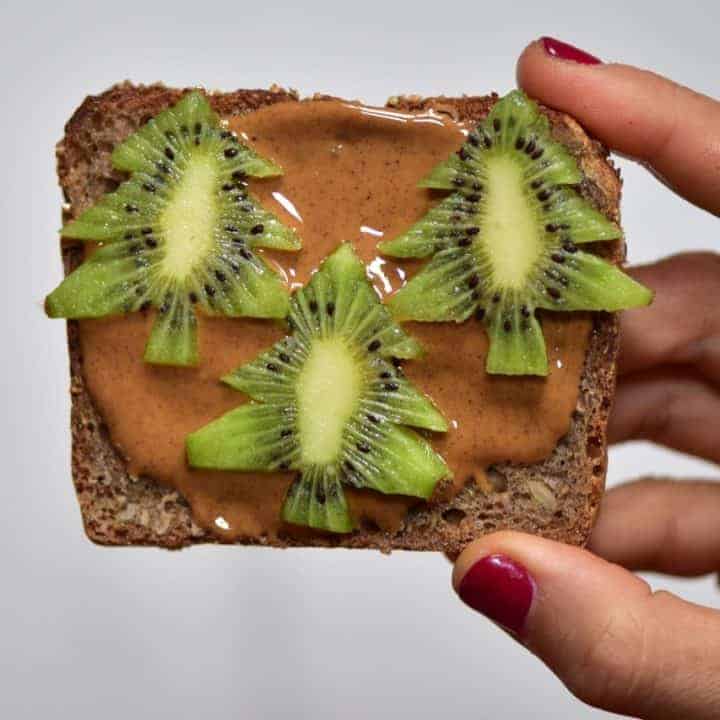 Christmas breakfast ideas perfect for christmas day breakfast - 9 healthy Christmas toast recipes including homemade nut butters, coconut yogurt and fruits. Plus these are easy Christmas recipes for Children- Almond butter toast with kiwi trees