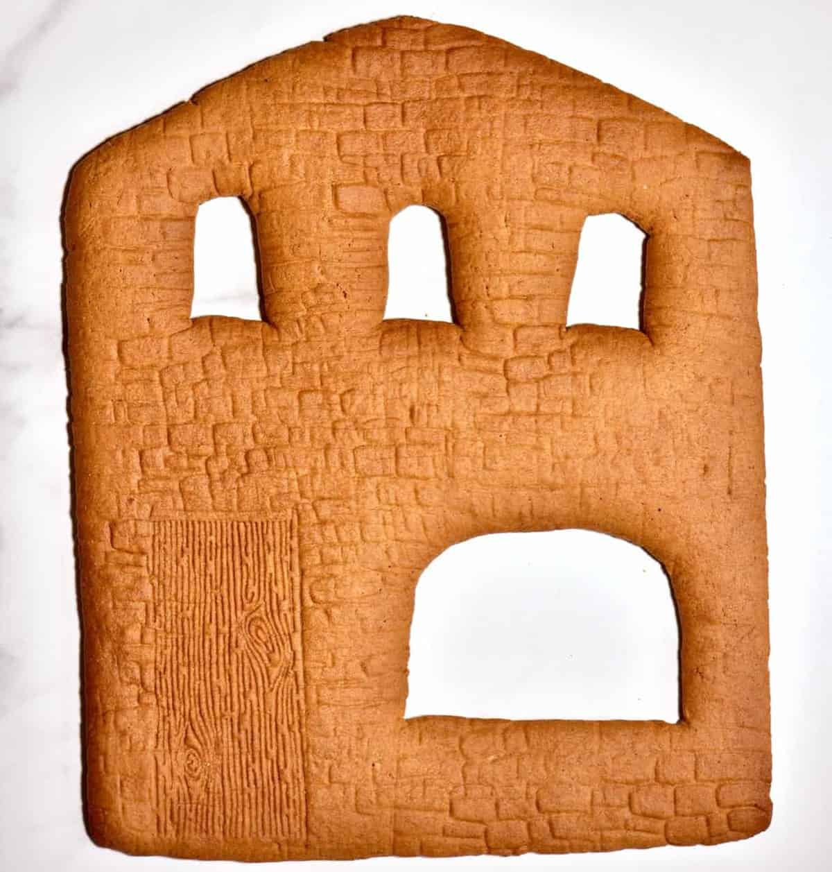 baked gingerbread house wall with cut off windows 